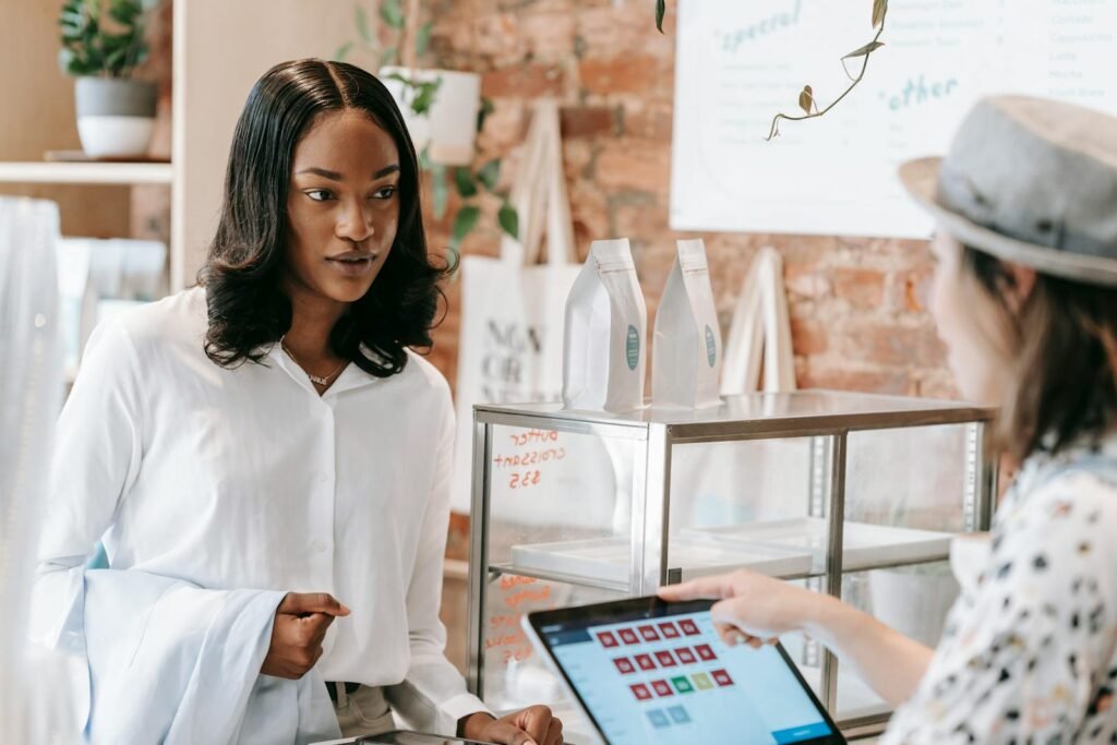 A customer interacts with a barista at a trendy coffee shop counter, showcasing modern retail service.